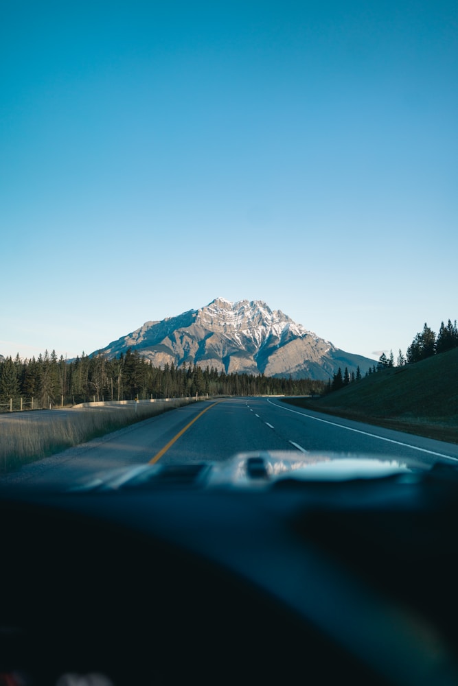 Road towards a mountain under a clear sky.